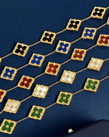 Gold floral-link jewellery arranged on a deep blue background