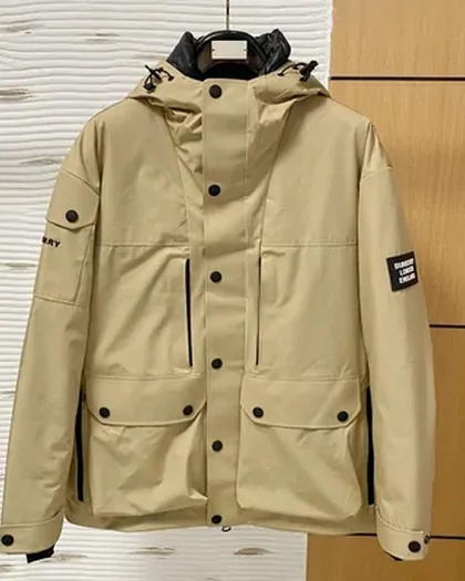 A beige hooded parka with four flap pockets, photographed flat against a pale wall