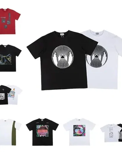 A black tee with a large circular print flanked by a red one and a white one, above a smaller group of folded tees